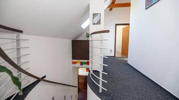 Uma escada moderna com corrimão de madeira e um hall com carpete.