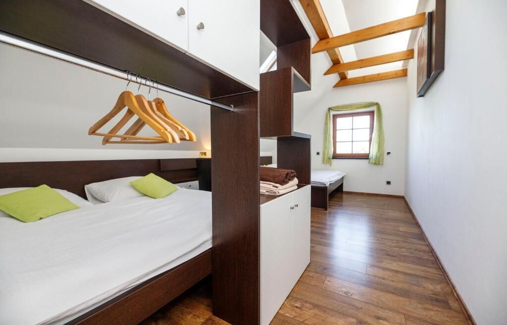 Ein Schlafzimmer mit einem Bett, einem Holzschrank und einem Fenster.