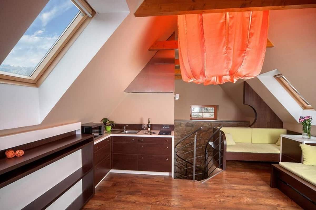 Um apartamento tipo loft moderno com cozinha, sala de jantar e mezanino com cama.