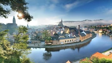 A riverside town with historic buildings, a prominent church tower, and a calm river.