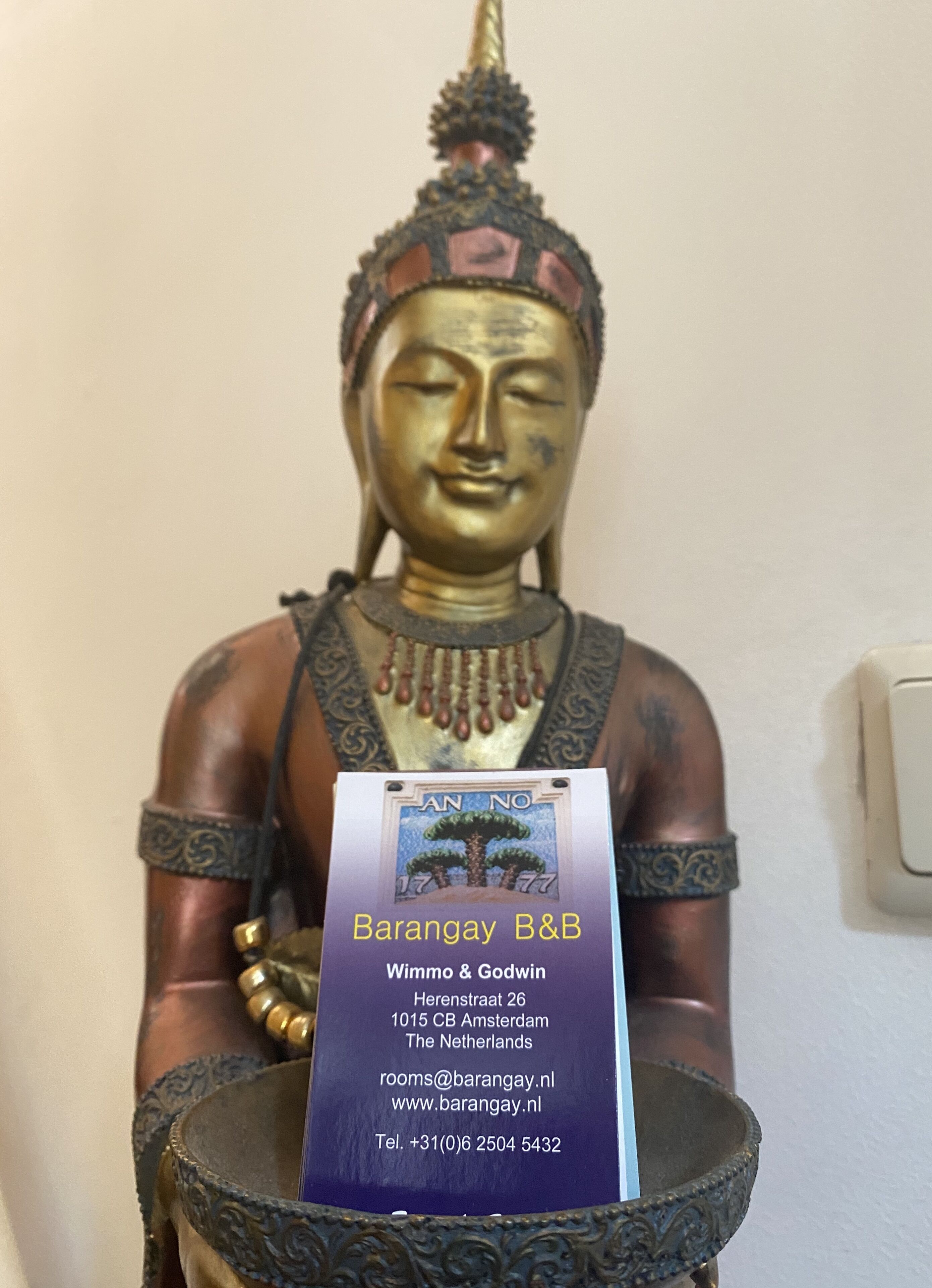Una estatua de Buda con una placa delante.