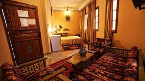 A traditional room with a sofa set, a bed, and a wooden cabinet. - Hotel Club Hanane (Ouarzazate)