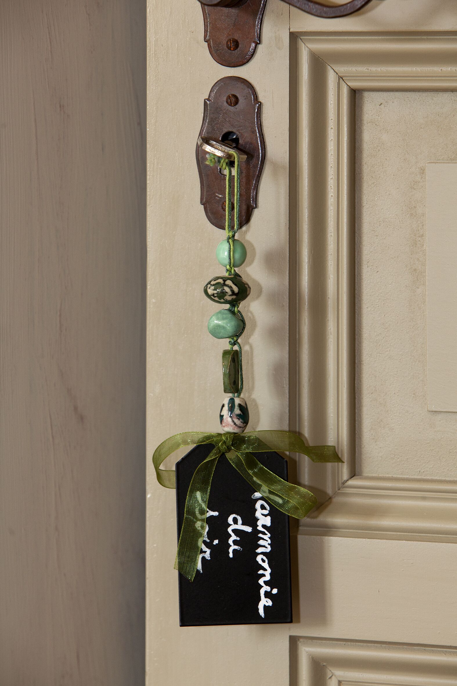 A door with a decorative key holder featuring a key and a small card with the word "harmony" written on it.