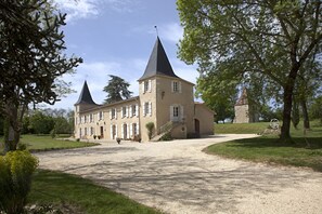 A large, historic building with two prominent towers, a gravel driveway, and surrounding greenery. - Maison d'hotes de Charme Les Bruhasses (Condom)