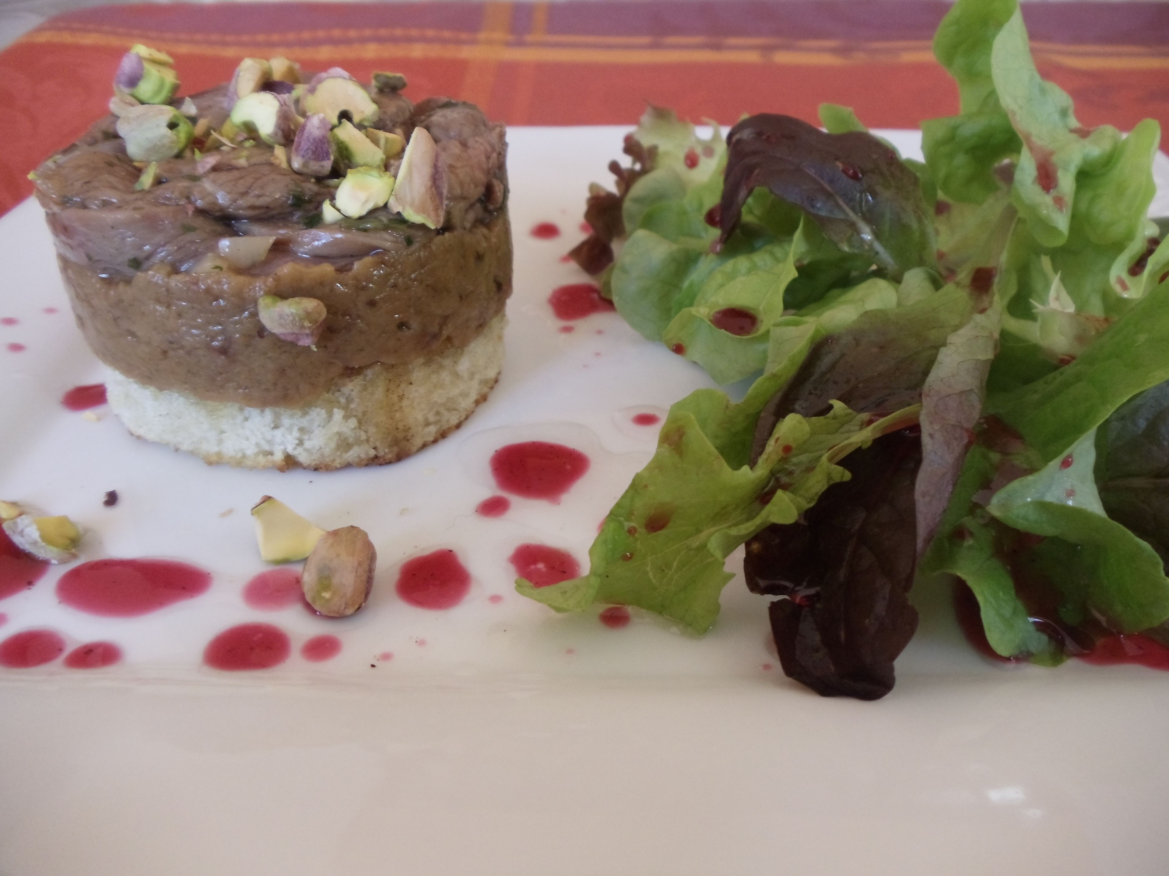 Un dessert aux noix et une salade verte sur une assiette blanche.