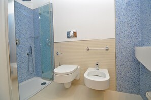 A modern bathroom with a glass-enclosed shower, a standard toilet, and a bidet. - Appartamento 5 Vele (Gallipoli)