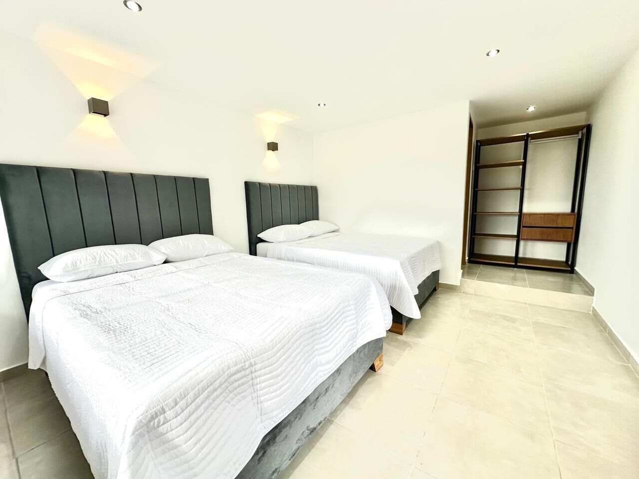 A hotel room with two beds, a walk-in closet, and a small sitting area.