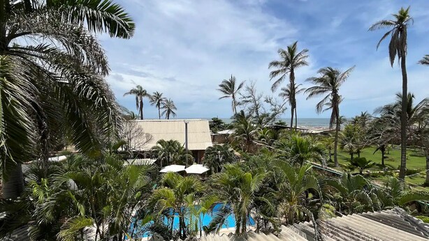 A resort with a pool, palm trees, and a view of the ocean. - Casa Berastegui (Puerto Colombia)