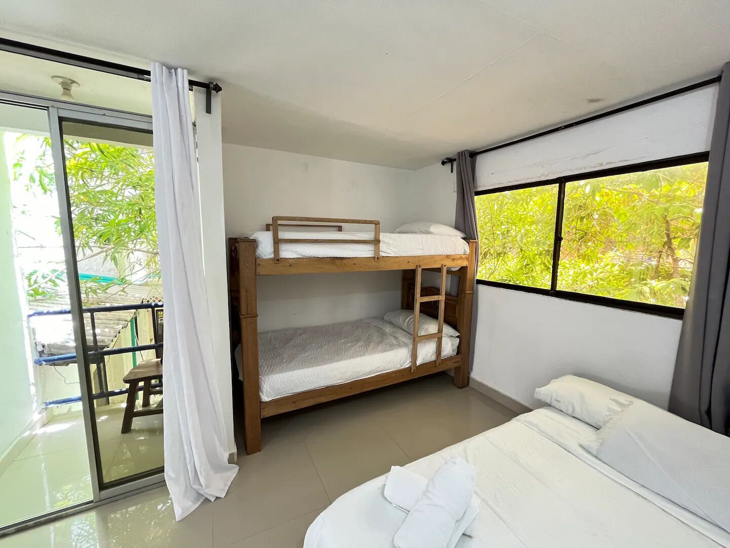 A bunk bed room with a large window and a balcony.