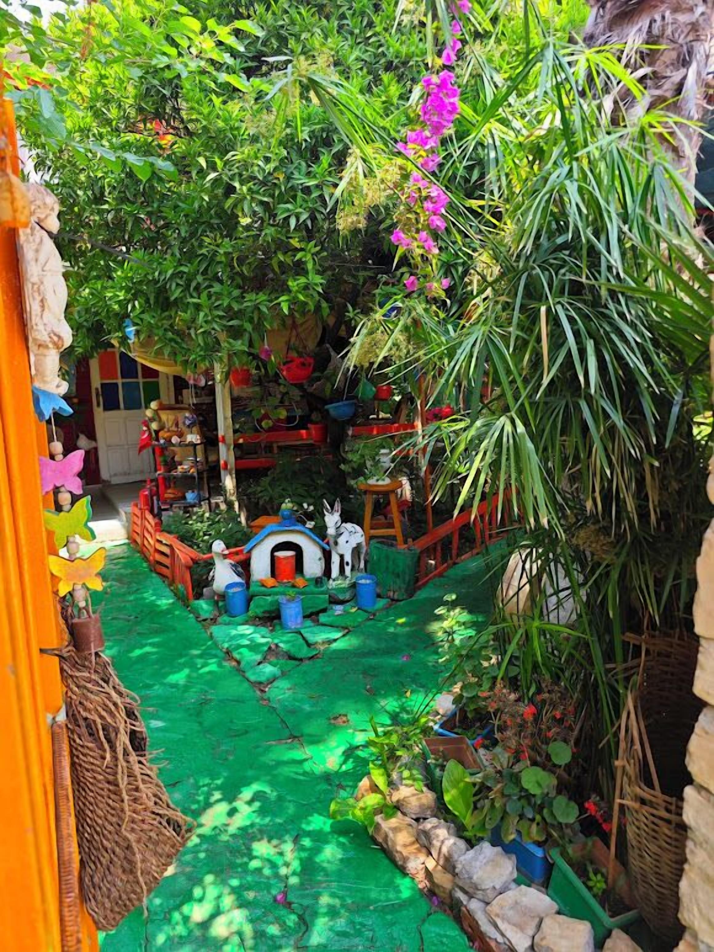 A vibrant garden with a variety of plants and a whimsical play area for children.