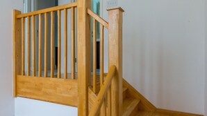 A wooden staircase with a handrail and a landing area. - Paradise at Little Bay Cournty Club (Negril)