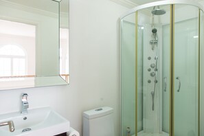 A modern bathroom with a glass-enclosed shower, a white sink, and a large mirror. - Paradise at Little Bay Cournty Club (Negril)