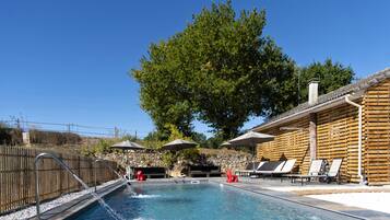 Piscine extérieure, piscine avec cascade, chaises longues