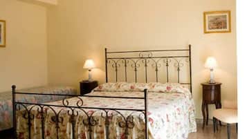 Quarto com uma cama de casal, duas mesas de cabeceira, luminária pendente e uma cadeira.