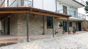A stone building with a wooden porch, a balcony, and potted plants. - Bed & Breakfast Villa Flora (Agropoli)