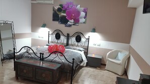 A bedroom with a bed, bedside tables, a chair, a dresser, and a wall-mounted air conditioner. - Bed & Breakfast Villa Flora (Agropoli)