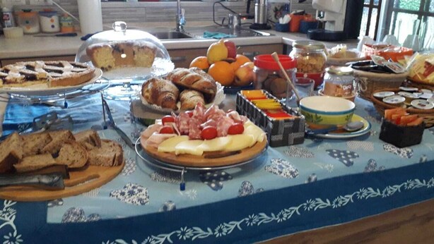 A buffet table with various food items including bread, pastries, cheese, and fruits. - Bed & Breakfast Villa Flora (Agropoli)