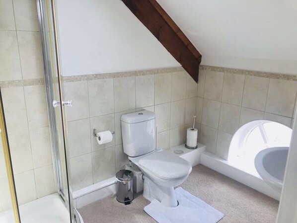 Une salle de bain moderne équipée de toilettes, d’un bidet et d’une baignoire.