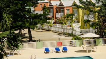 Alberca al aire libre, sombrillas en la alberca y camastros