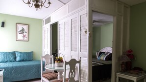 A room with a dining table, chairs, a sofa, and a bed. - Deluxe Turtle Towers Apartments (Ocho Rios)