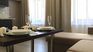 A dining area with a table set for two, featuring white plates, glasses, and candles. - Euro Apartments Lidická 39 Brno (Brno)