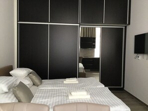 Een hotelkamer met een bed, een televisie en een kledingkast.