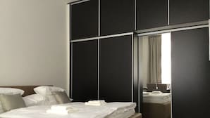 A modern hotel room with a large bed, a seating area, and a large mirror reflecting the room. - Euro Apartments Lidická 39 Brno (Brno)