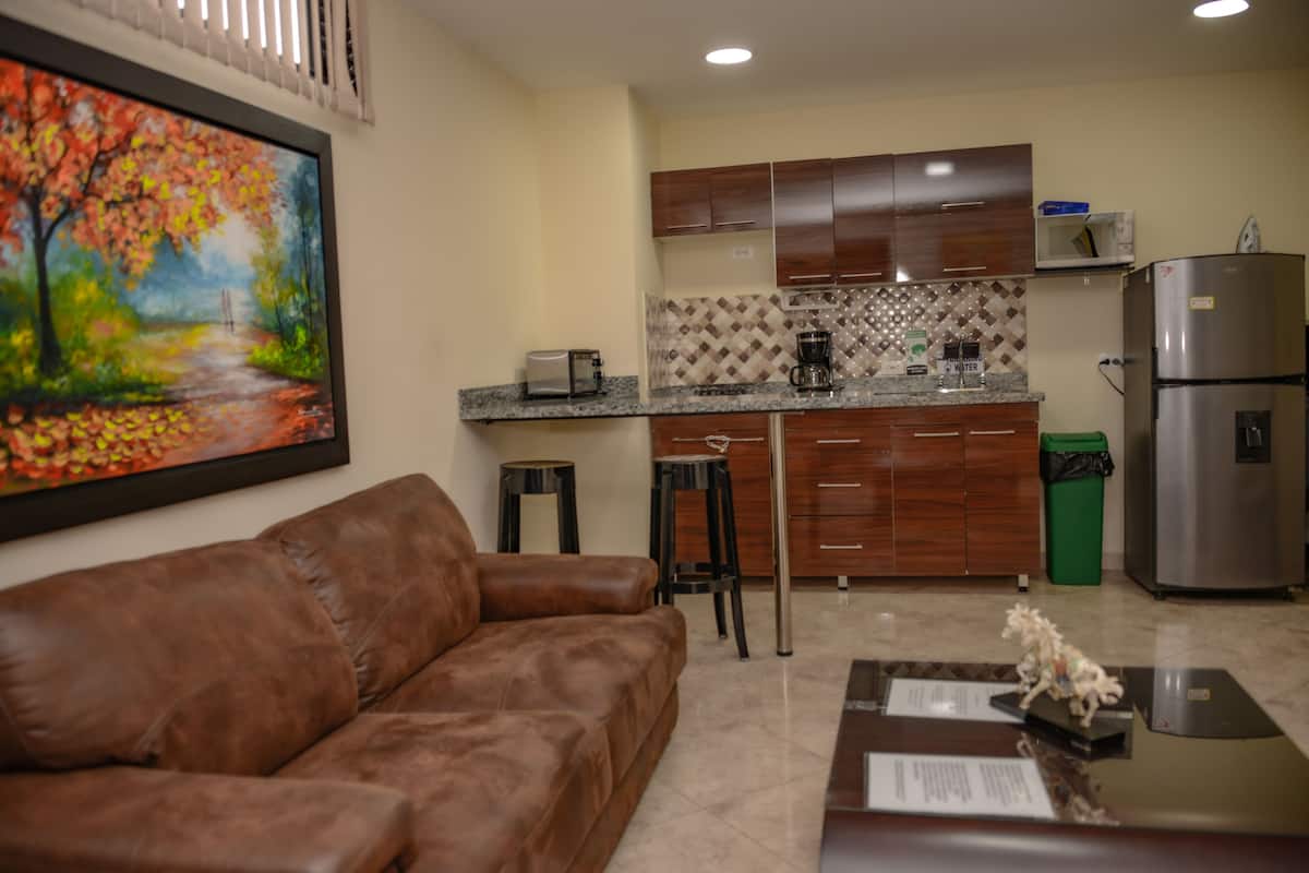 A modern kitchen with wooden cabinets, a stainless steel refrigerator, and a microwave.