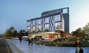 A modern hotel with a glass facade, a prominent AC logo, and a landscaped entrance area. - AC Hotel by Marriott Sunnyvale Cupertino (Sunnyvale)