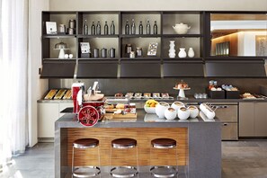 Una cocina moderna con una isla central, taburetes de bar y una variedad de utensilios y electrodomésticos.