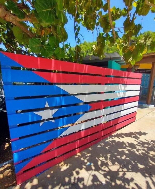 A colorful fence with a star and stripes, likely a decorative element in a garden or outdoor area.
