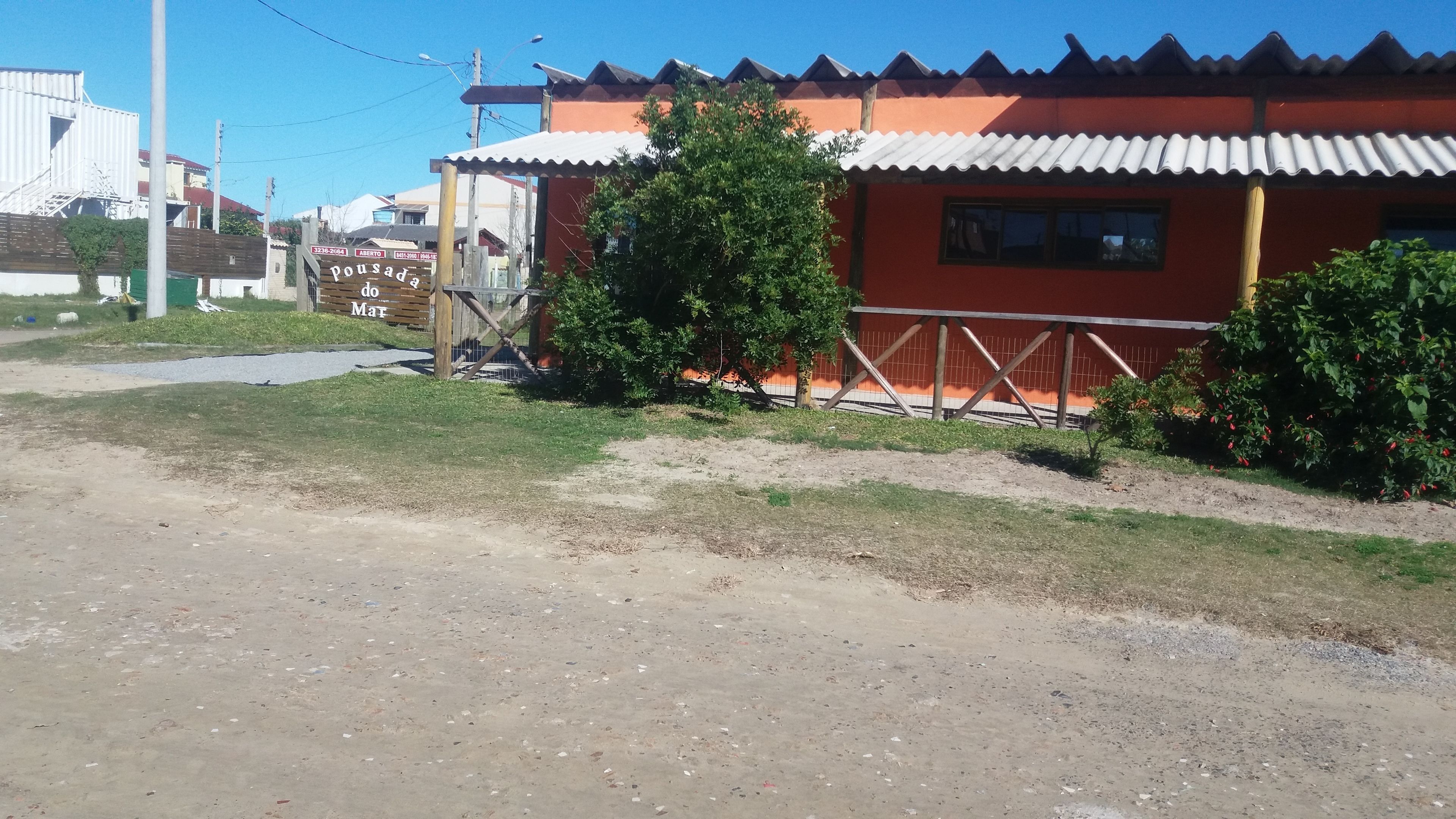 A building with a corrugated metal roof and a wooden fence.