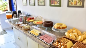 Un buffet de petit-déjeuner proposant divers plats et un gâteau exposé sur un comptoir.