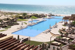 Una piscina al aire libre, sombrillas, tumbonas