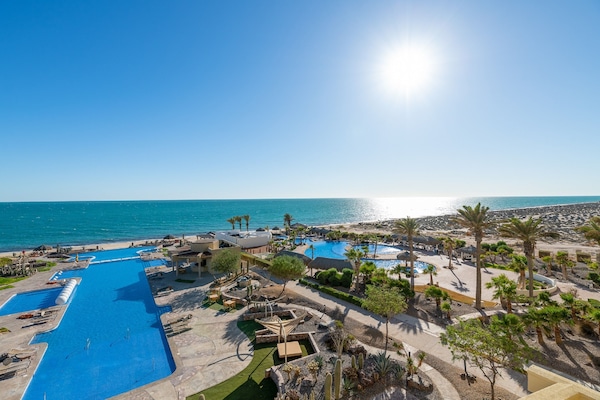 Una piscina al aire libre, sombrillas, tumbonas