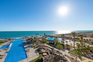Una piscina al aire libre, sombrillas, tumbonas