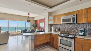 Una cocina moderna con una isla grande, electrodomésticos de acero inoxidable y armarios de madera.