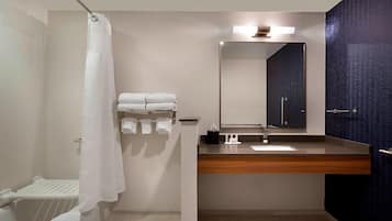 A modern bathroom with a shower, a sink with a mirror, and a towel rack.