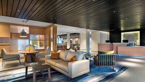 A modern hotel lobby with a sofa, chairs, a coffee table, and a reception desk. - Fairfield Inn & Suites by Marriott Shelby (Shelby)