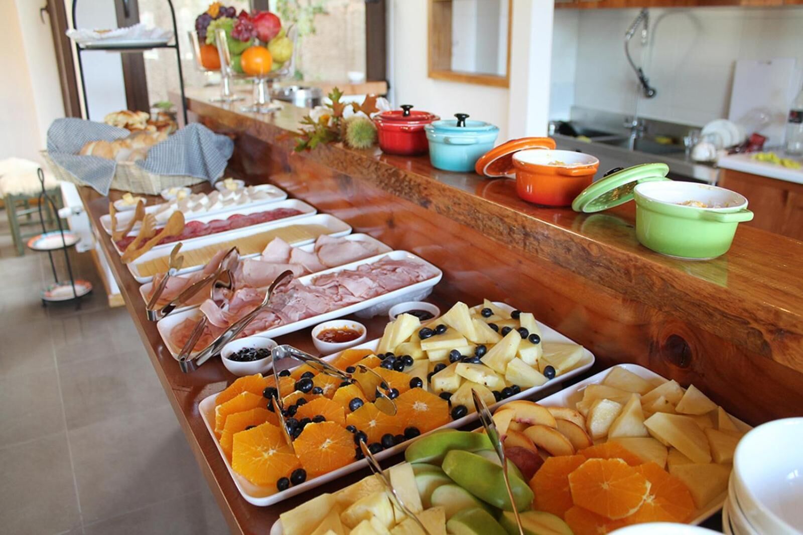 A buffet with various food items including fruits, meats, and cheeses.
