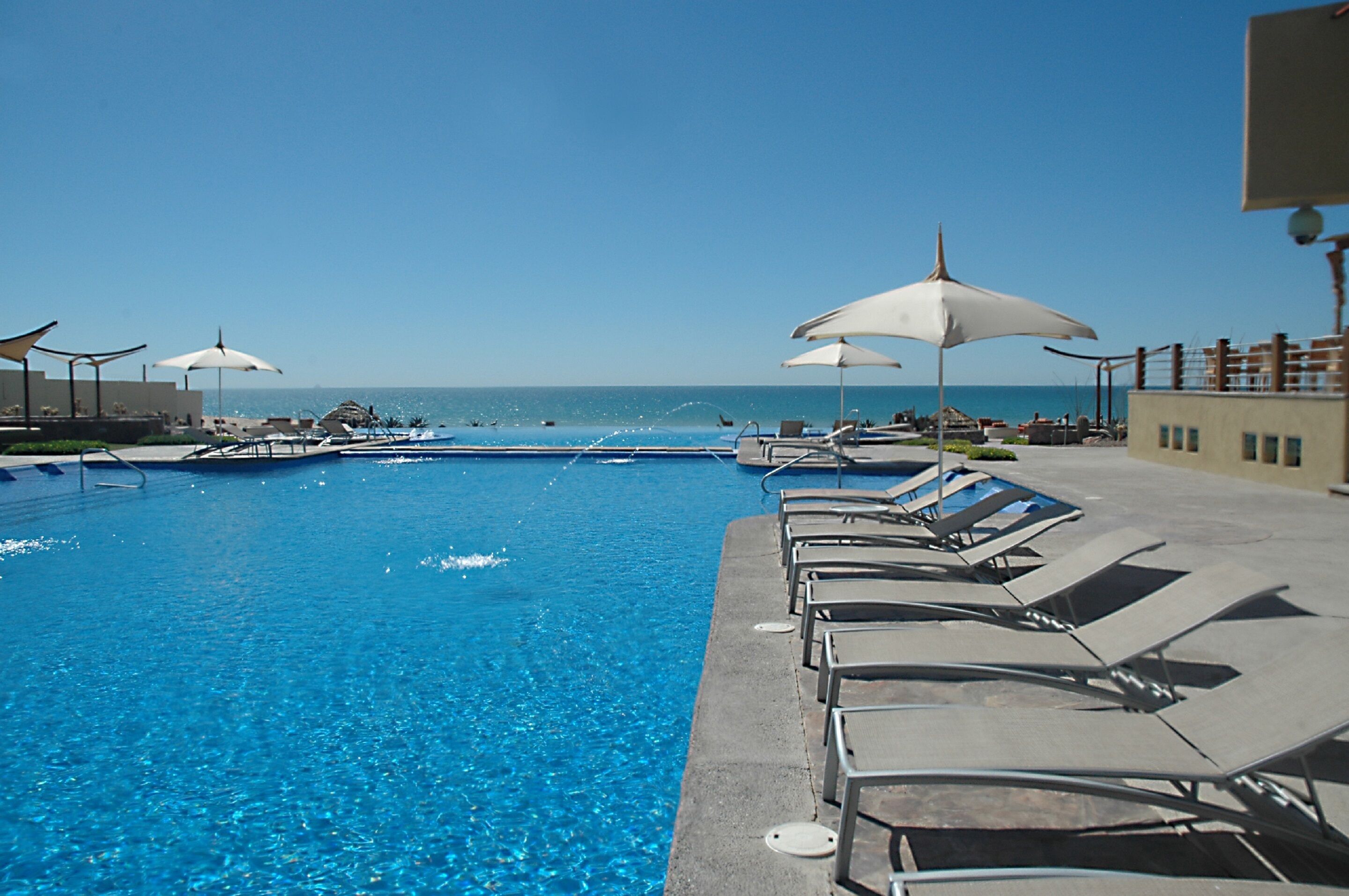 Outdoor pool, an infinity pool, pool umbrellas, pool loungers