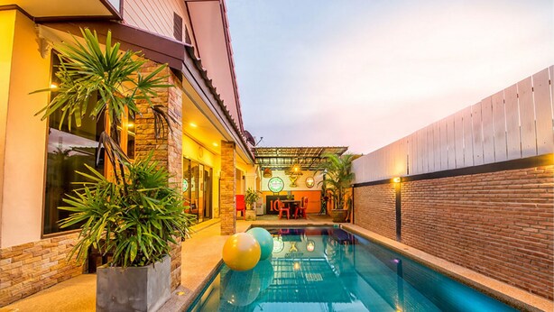 A swimming pool with a brick wall and a covered patio area. - Baan Por Jai HuaHin Pool Villa (Hua Hin)