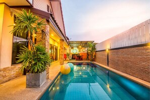 A swimming pool with a brick wall and a covered patio area. - Baan Por Jai HuaHin Pool Villa (Hua Hin)