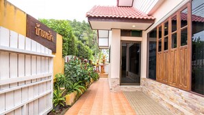 A pathway leading to a building with a tiled roof and large windows. - Baan Por Jai HuaHin Pool Villa (Hua Hin)