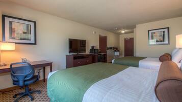 A hotel room with two beds, a desk with a chair, a television, and a microwave.