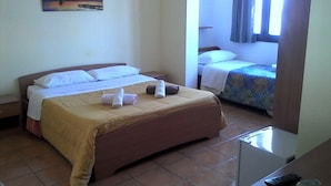 A hotel room with a large bed, a smaller bed, a desk with a remote control, and a painting on the wall. - Oasi B&B (Porto Cesareo)