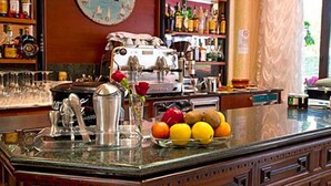Eine Bar mit Uhr, Barhocker und einer Auswahl an Flaschen.