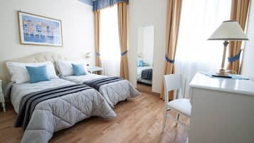 Una camera d'albergo con un letto, comodini, una scrivania, una sedia e uno specchio grande.