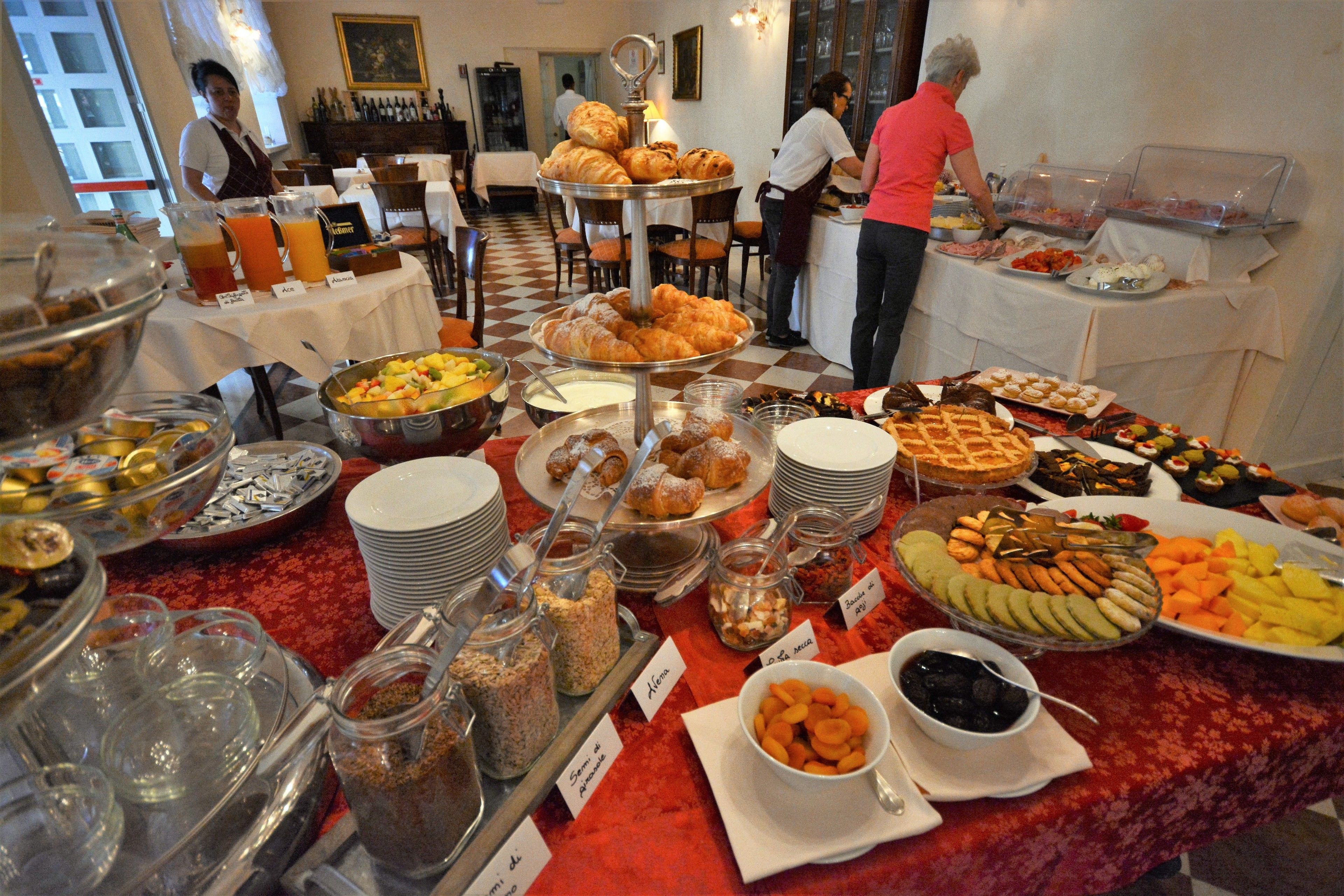 Un buffet con diversi cibi e un pavimento a scacchi.