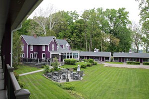 Un edificio grande de color morado con un patio cubierto y varios edificios más pequeños al fondo.